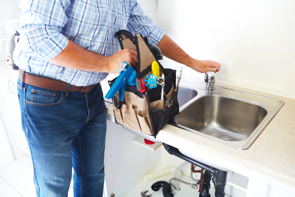 man doing kitchen plumbing